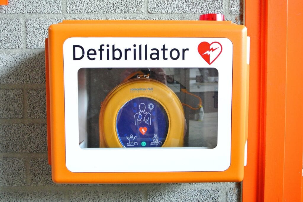 Ein Defibrillator in einer Wandhalterung.