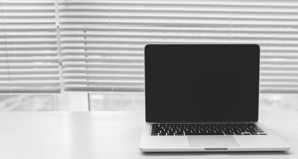 Laptop steht aufgeklappt auf einem Tisch.