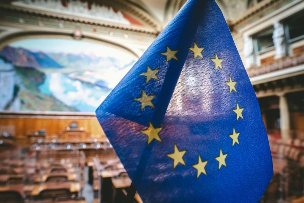 Bild einer EU-Flagge in einem großen Saal.